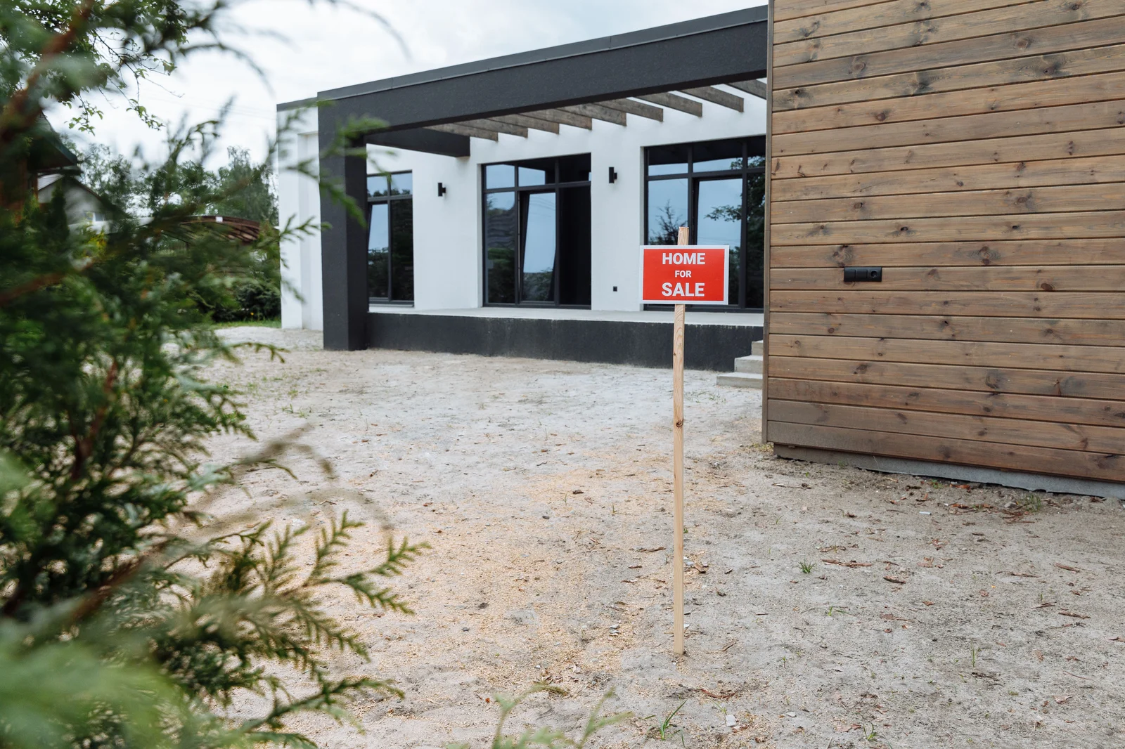 Maison moderne avec un panneau « à vendre » dans le jardin