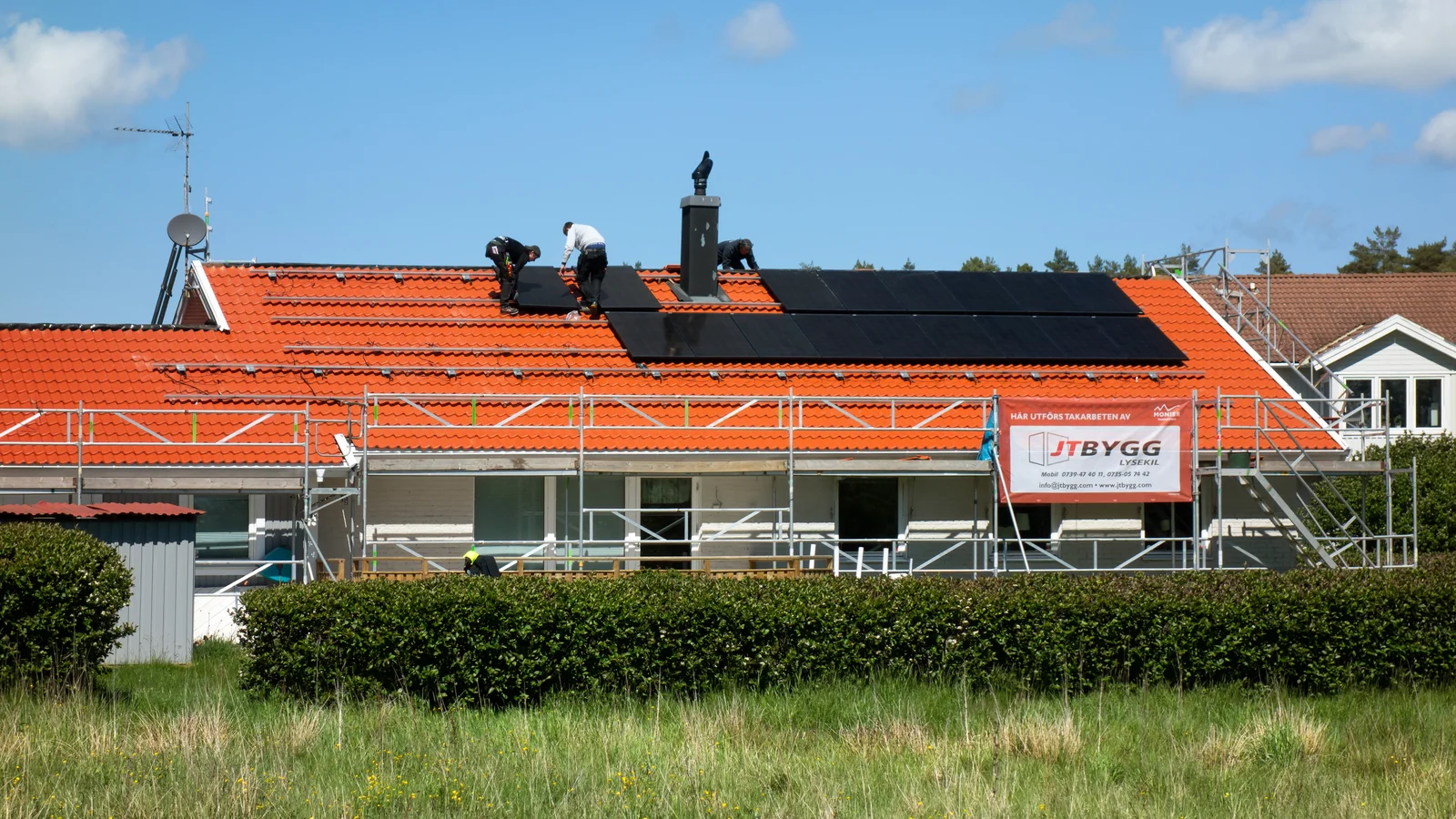 Installation de panneaux solaires par des techniciens sur le toit d'une maison, première étape d'une opération d'autoconsommation collective