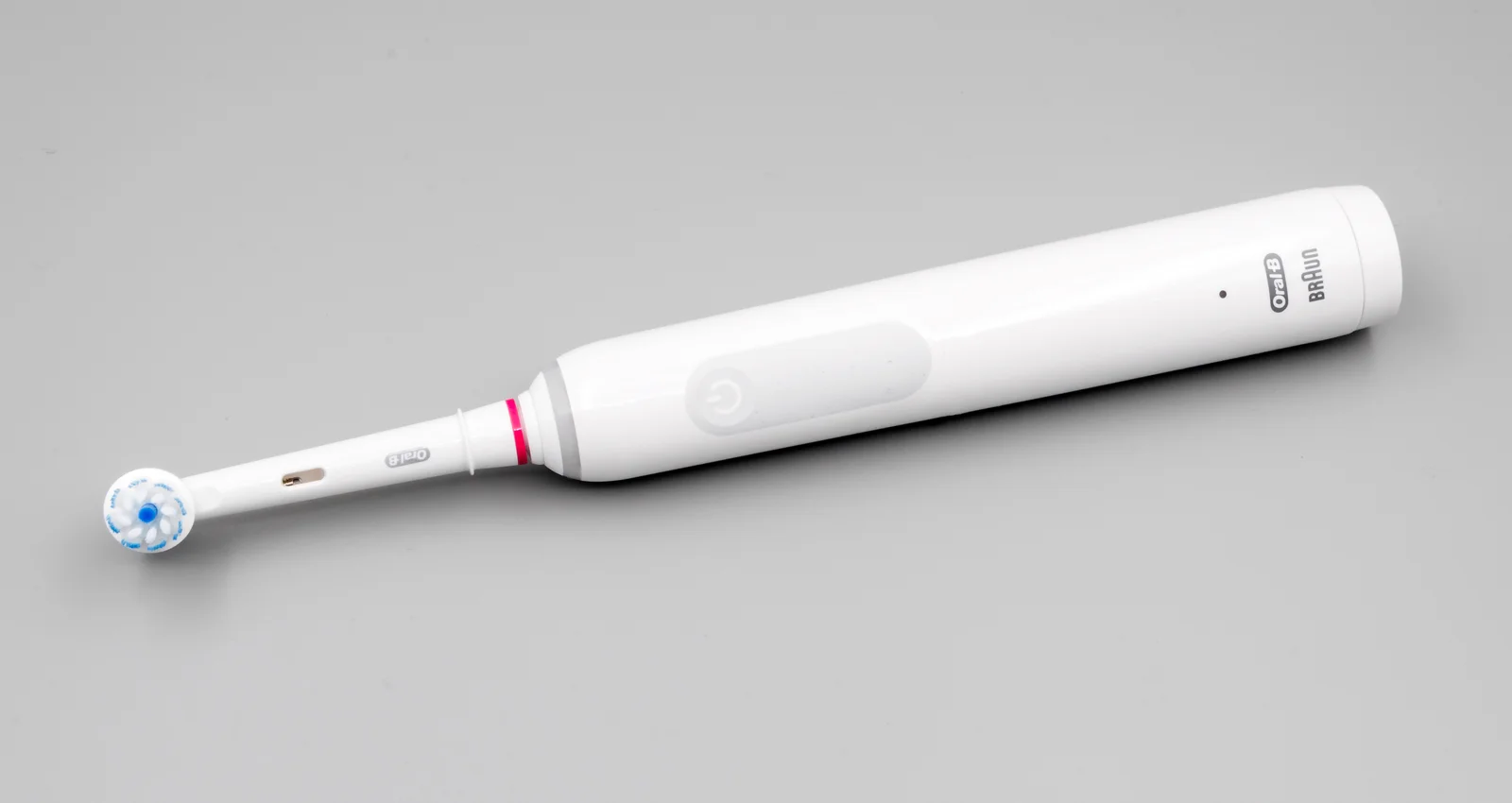 Brosse à dents électrique connectée de la marque Oral-B posée sur une surface claire