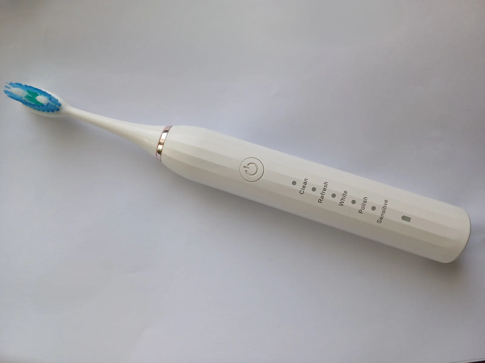 Brosse à dents électrique blanche posée sur fond neutre en gros plan