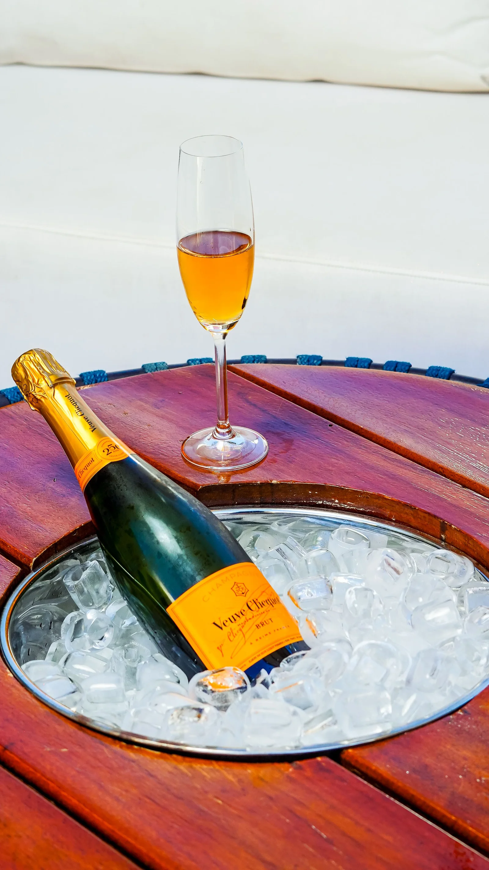 Bouteille chillée dans un seau à glace posé sur une table en bois — conservation et service du vin