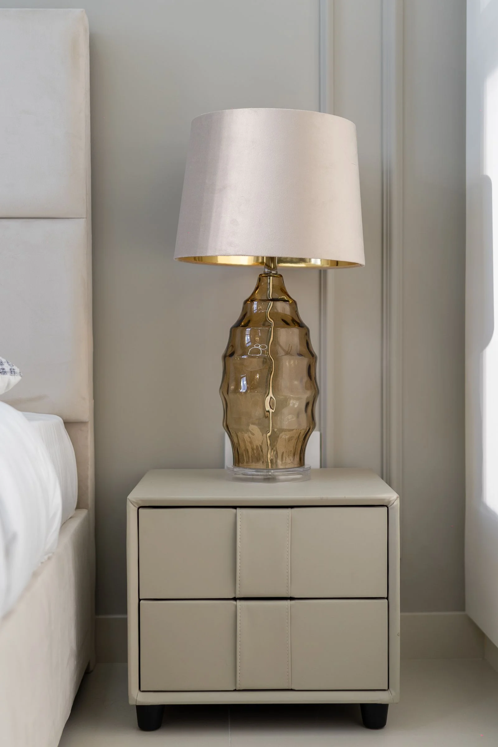Table de chevet moderne avec lampe dans une chambre lumineuse