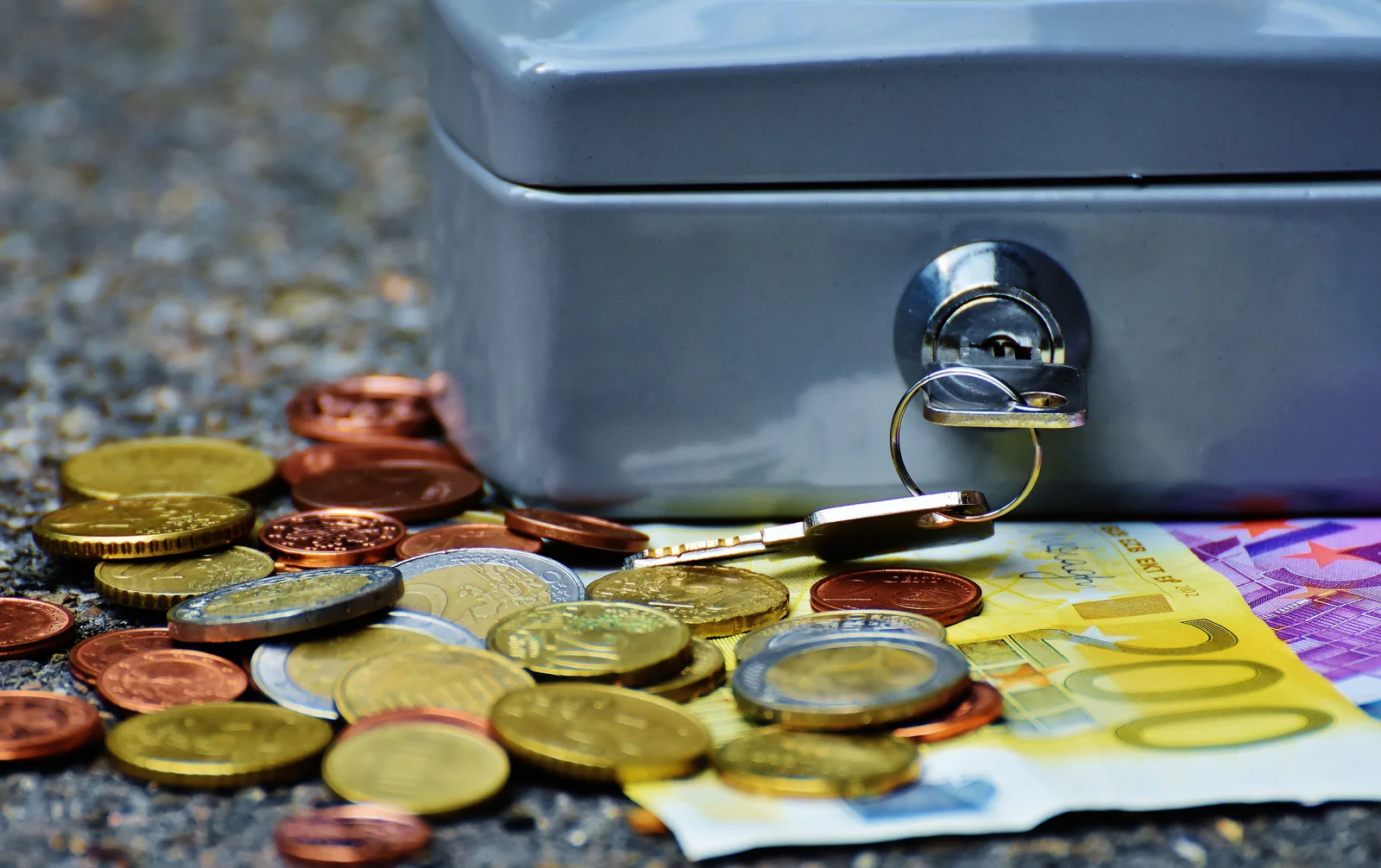 Coffre-fort connecté avec billets et pièces symbolisant la sécurité financière