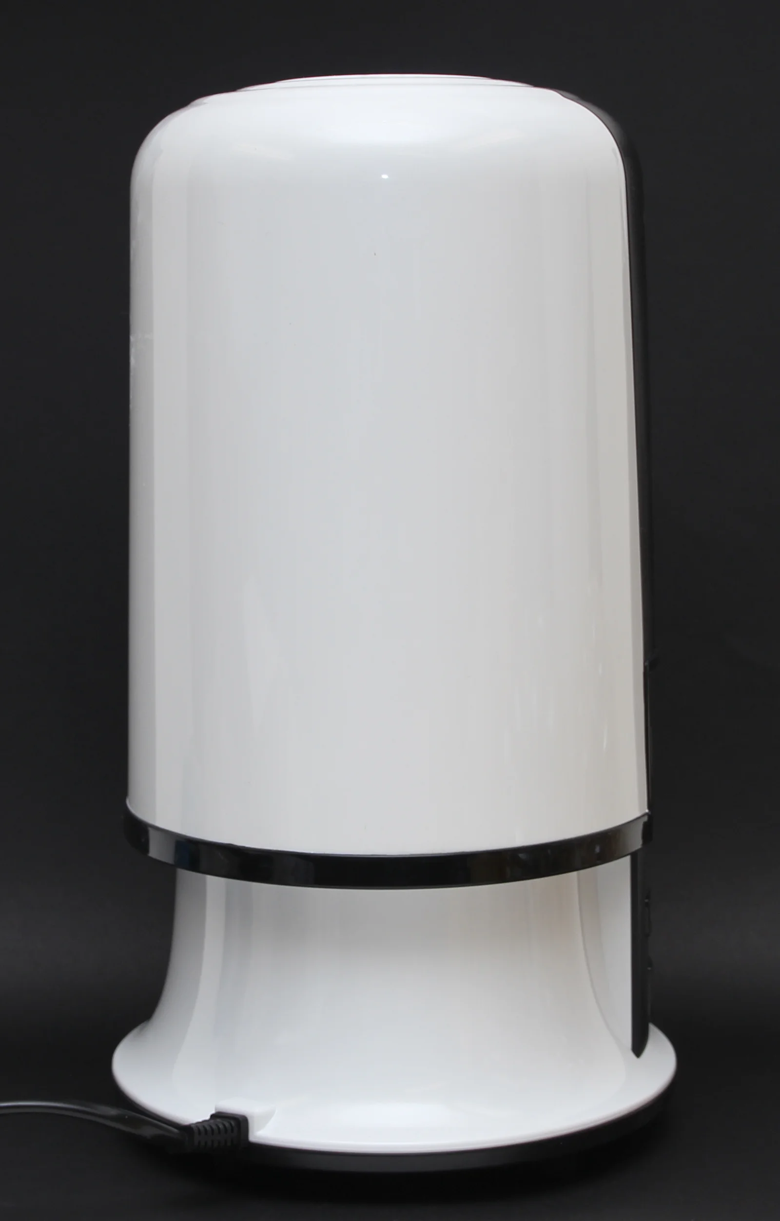 Diffuseur de parfum connecté vu de profil avec réservoir d'eau visible sur une table basse