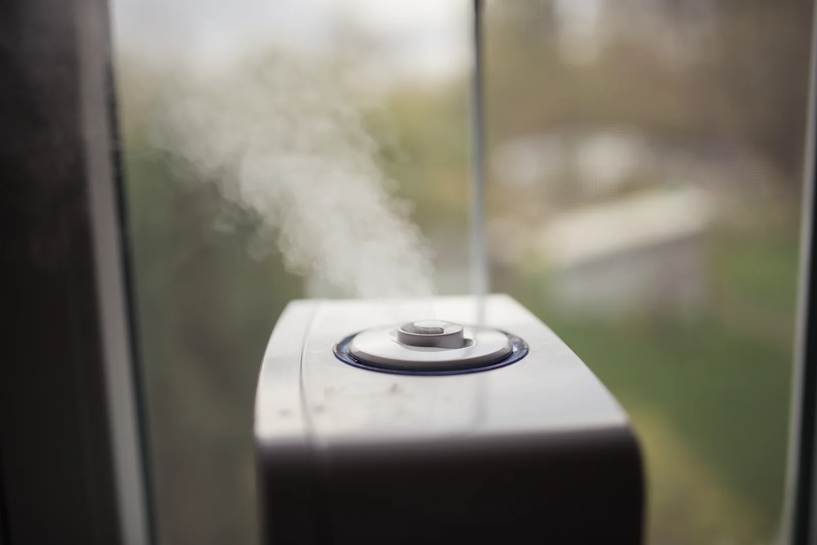 Diffuseur de parfum connecté en fonctionnement avec vapeur visible dans une pièce moderne