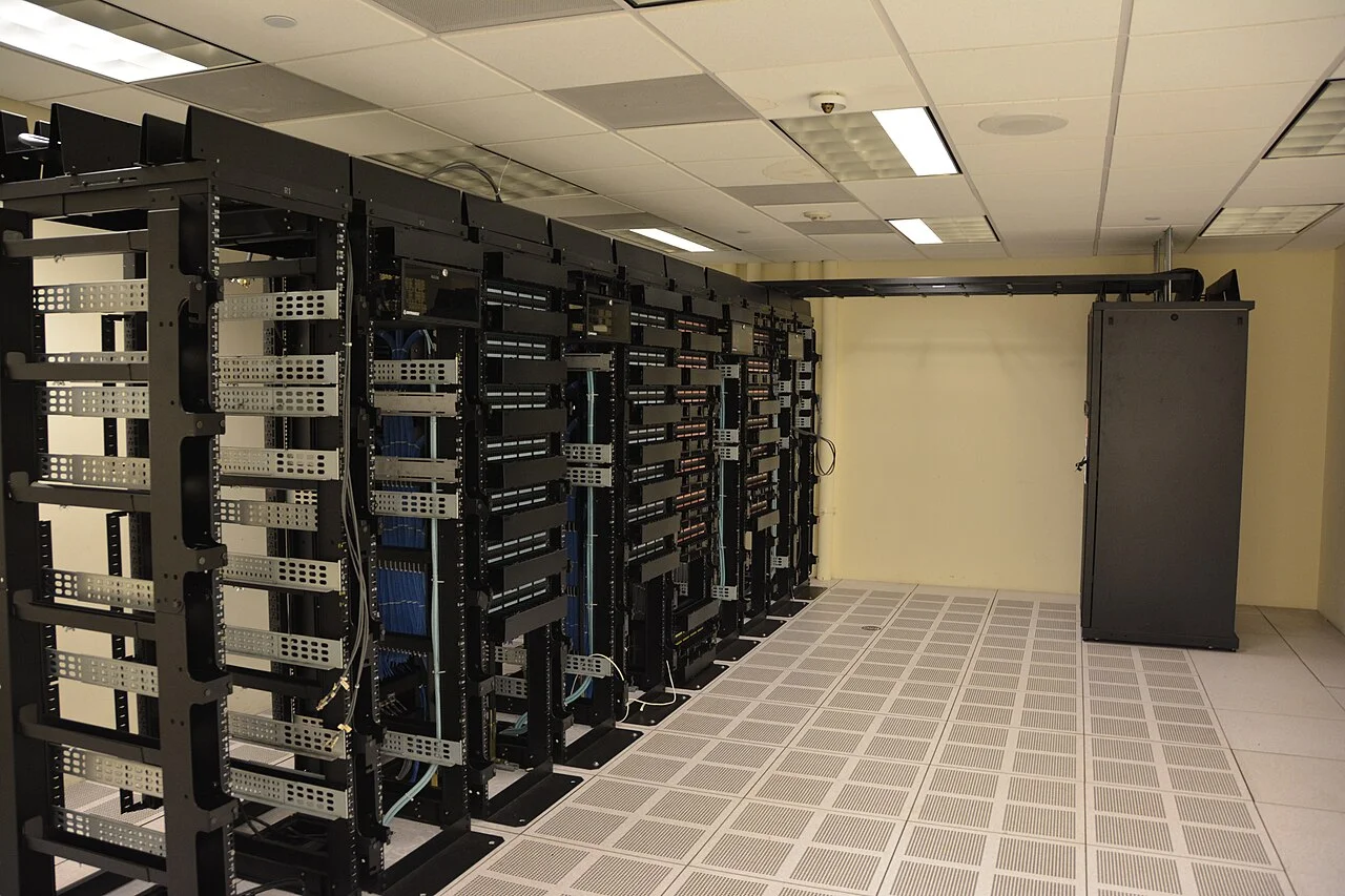 Rangées de serveurs dans un centre de données représentant l'infrastructure cloud utilisée par les assistants vocaux