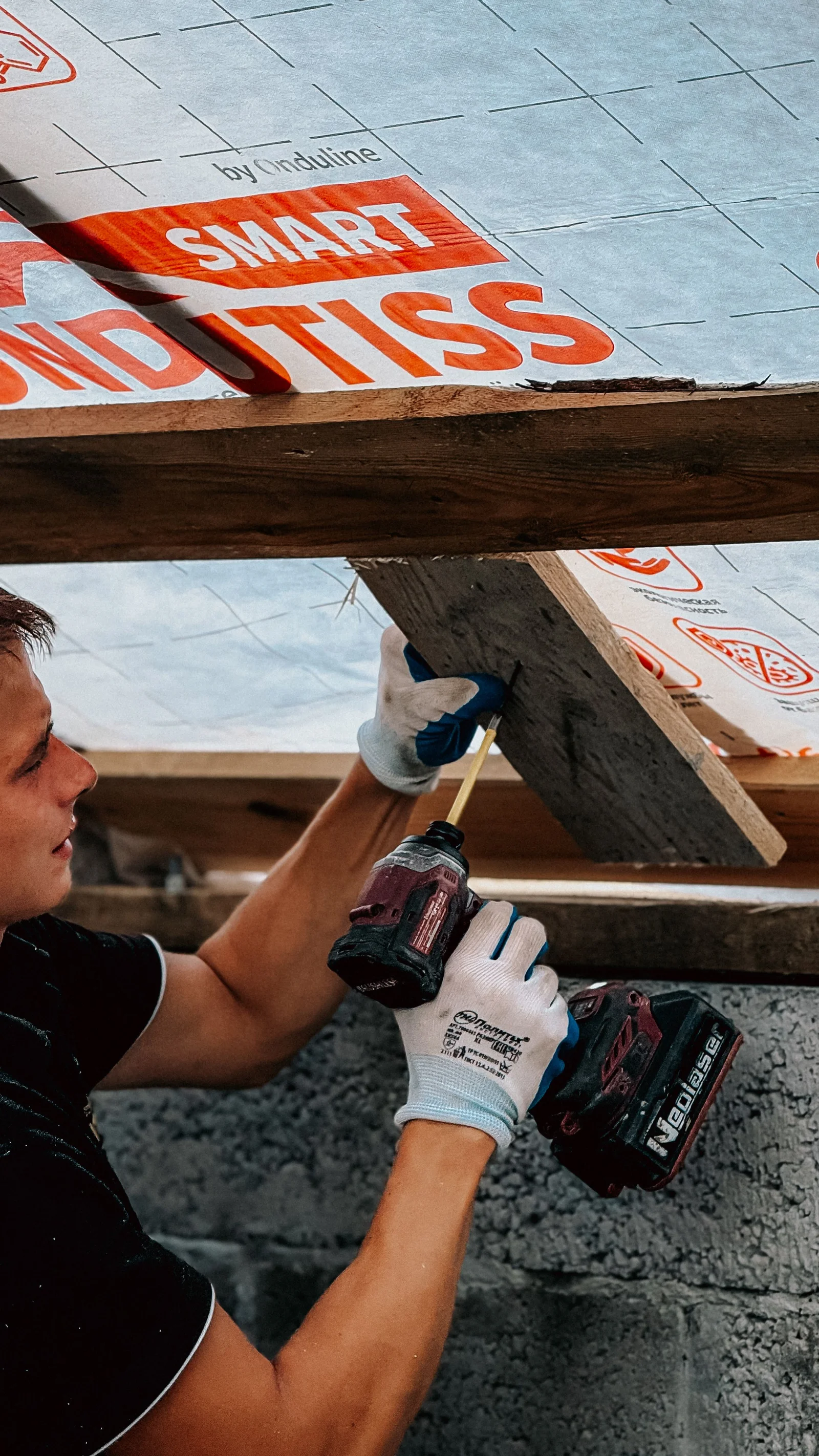 Ouvrier installant une isolation de toiture, travaux souvent associés aux équipements de régulation connectée éligibles aux aides