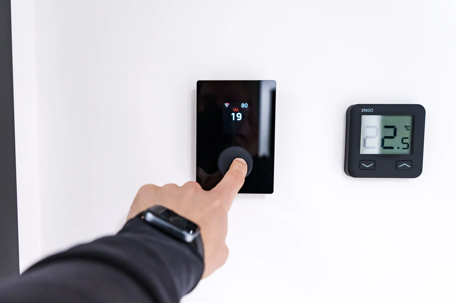 Installation d'un thermostat connecté sur un mur, équipement éligible à une prime CEE de régulation du chauffage