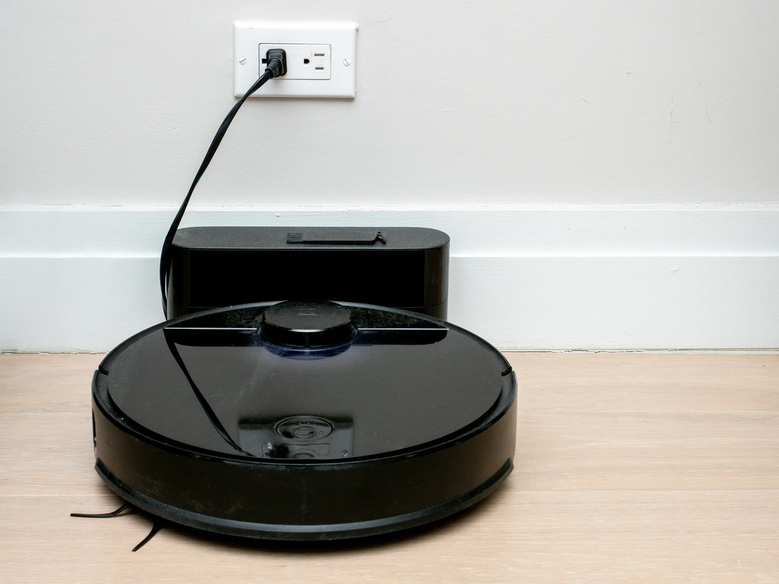 Robot aspirateur Roborock en charge sur sa base — application mobile connectée