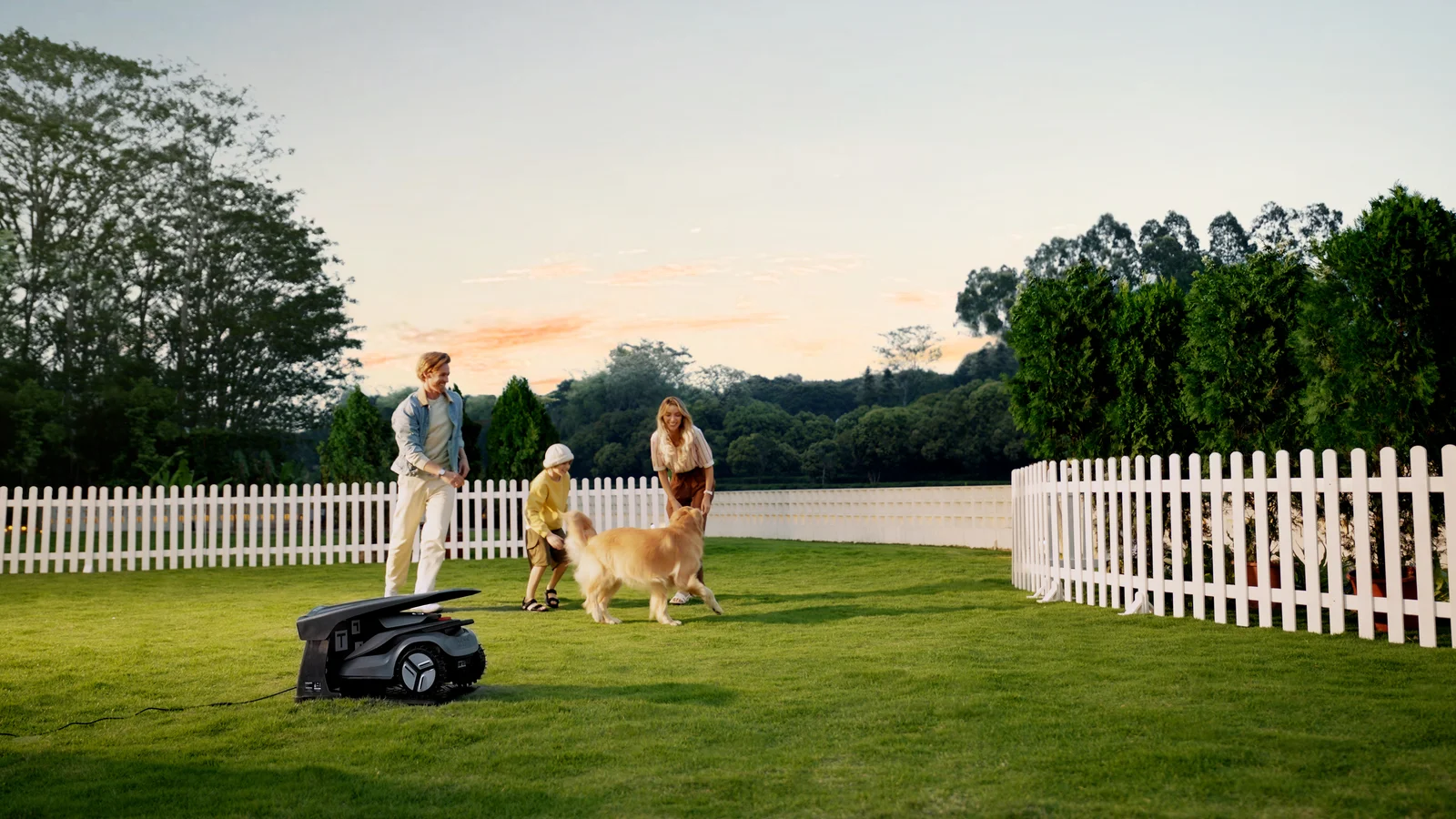 Robot tondeuse TerraMow V1000 avec sa caméra TerraVision visible, dans un jardin avec une niche pour chien