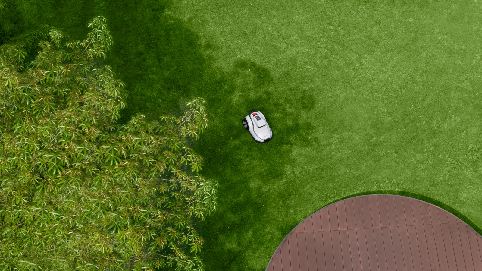 Vue aérienne d'un robot tondeuse TerraMow en train de tondre un jardin près d'une terrasse en bois