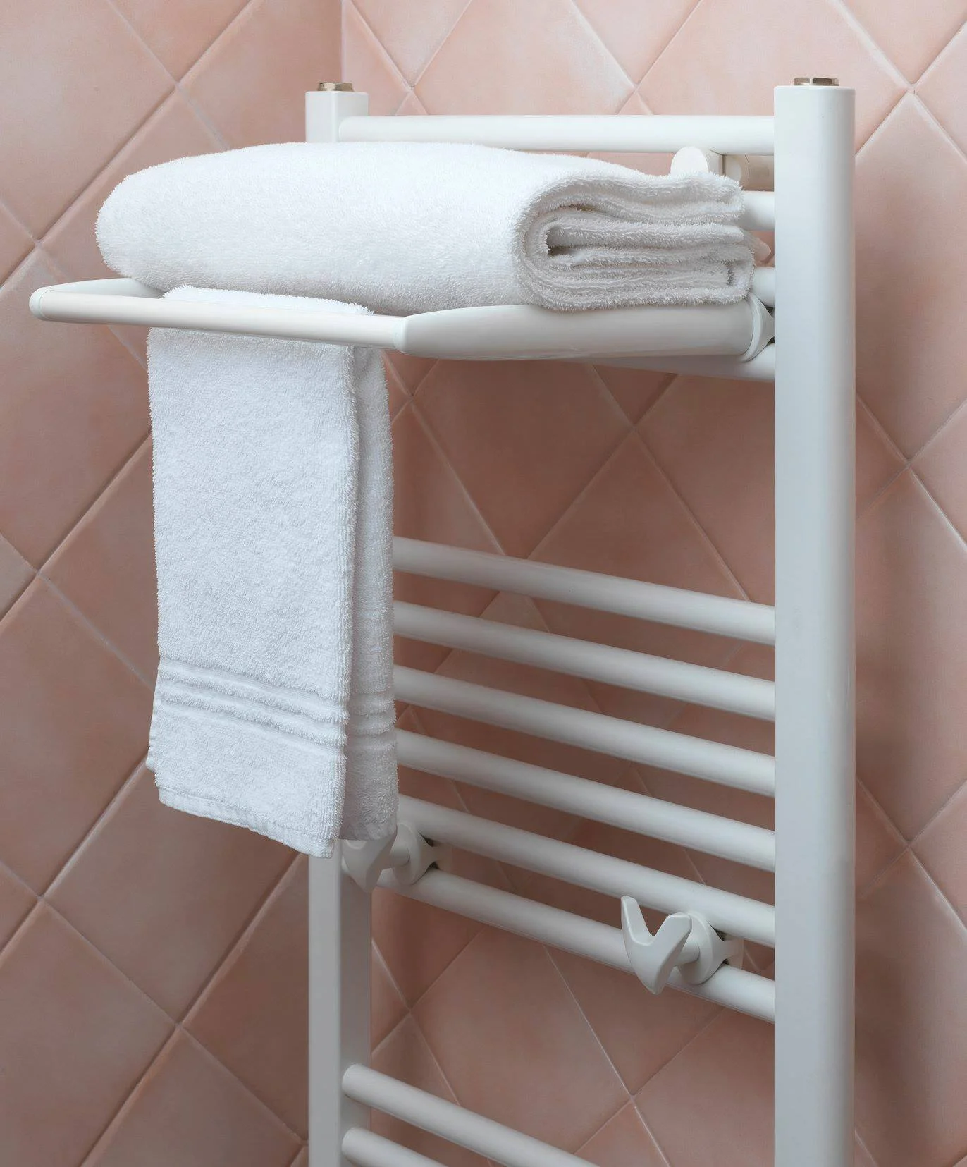 Radiateur sèche-serviette blanc de type échelle avec porte-serviette dans une salle de bain