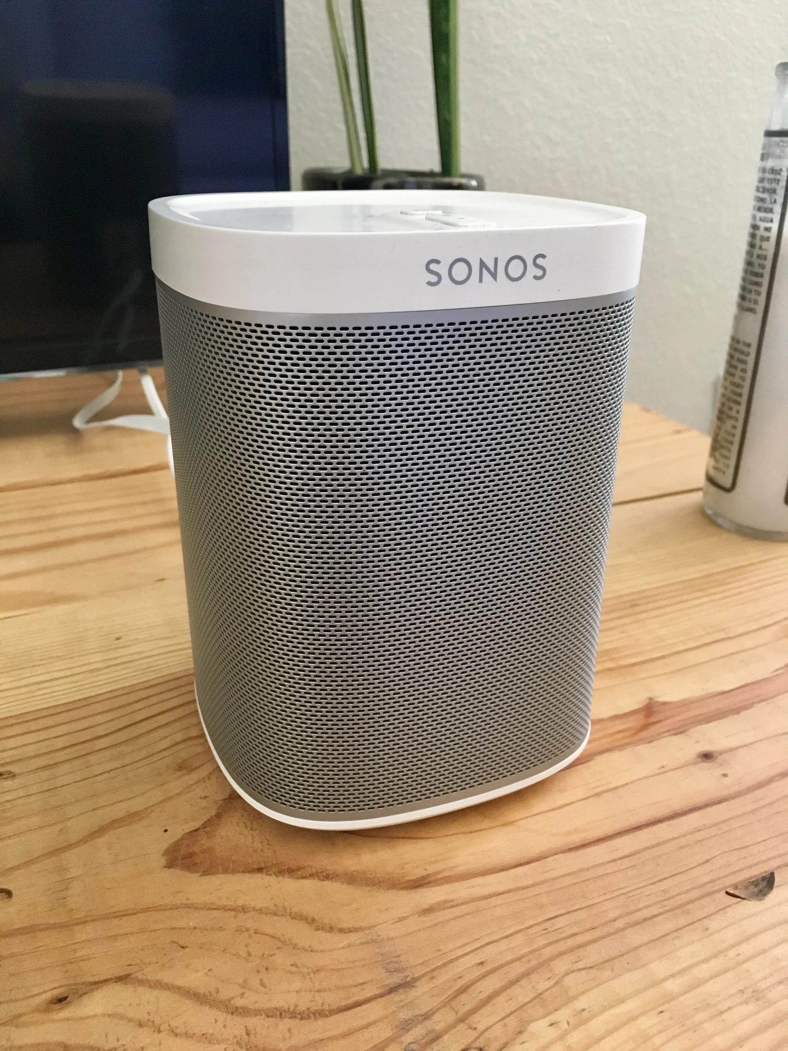 Enceinte Sonos One blanche posée sur un meuble dans un intérieur lumineux