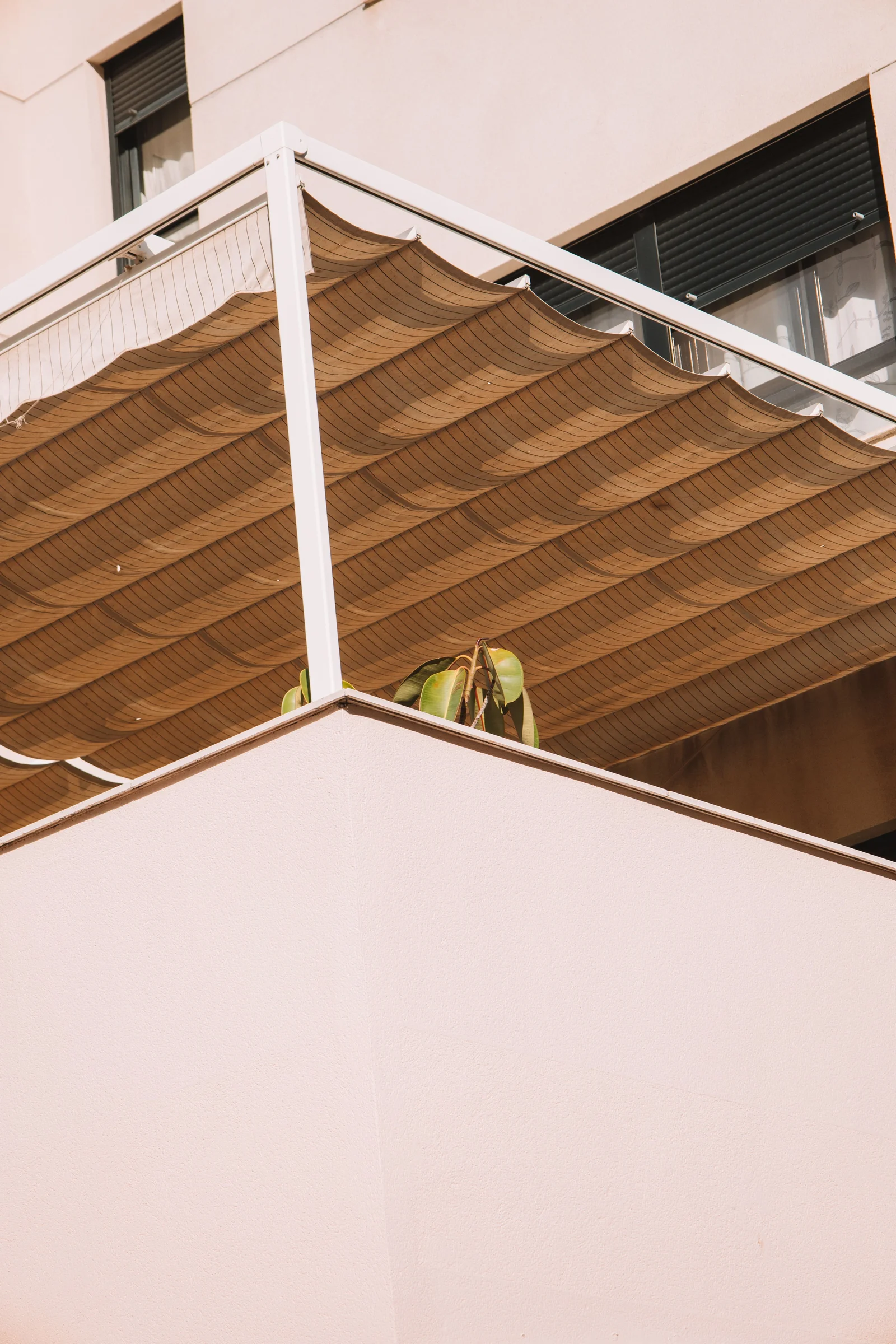Balcon avec store offrant de l'ombre, réduisant la chaleur ressentie en intérieur