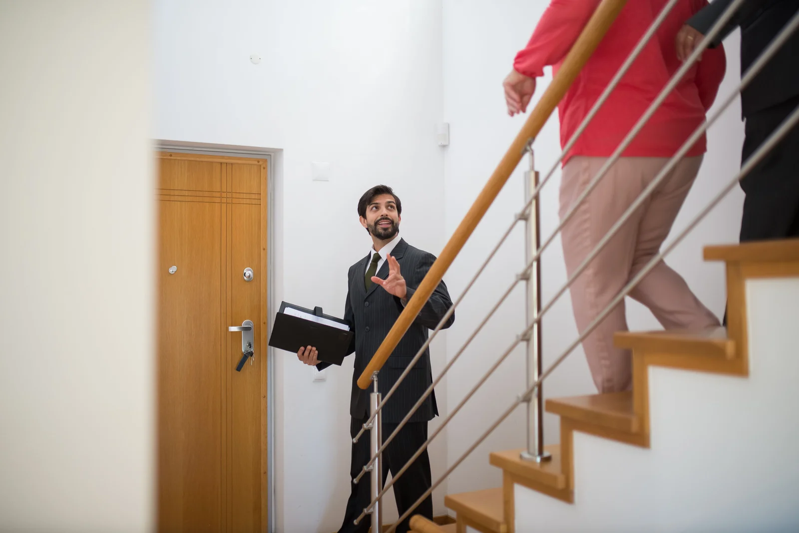 Agent immobilier faisant visiter une maison moderne à des acheteurs potentiels